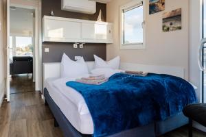 Un dormitorio con una cama grande con una manta azul. en Hausboot Arielle, en Ribnitz-Damgarten