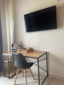 una scrivania con sedia e una TV appesa a un muro di B&B zio Domenico a Grumento Nova