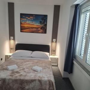 ein Schlafzimmer mit einem Bett mit zwei Handtüchern darauf in der Unterkunft Barka Zadar in Zadar