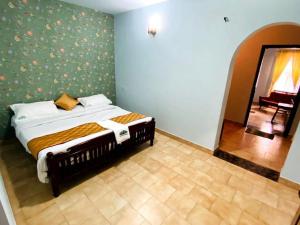 a bedroom with a bed in a room with a mirror at BOB Leisure in Ooty