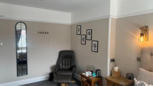 a living room with a black chair and a table at The Red Lion Hotel in Cromer