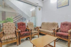 una sala de espera con 3 sillas y una mesa en OYO 79037 Metro Lodge en Hyderabad