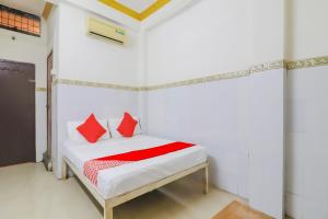 Un dormitorio con una cama con almohadas rojas. en OYO 79037 Metro Lodge en Hyderabad