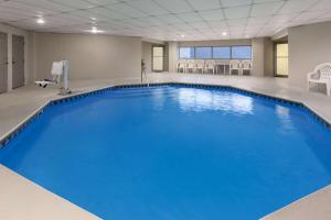 uma grande piscina azul num quarto com cadeiras em Days Inn by Wyndham Chattanooga Lookout Mountain West em Chattanooga