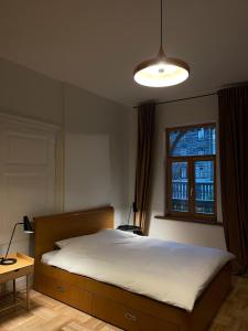 Un dormitorio con una cama grande y una ventana en Sisters Beach Apartments, en Liepāja