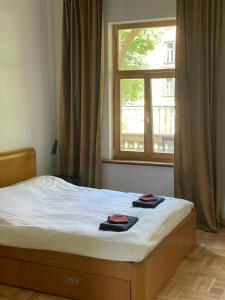 1 cama con 2 toallas en una habitación con ventana en Sisters Beach Apartments, en Liepāja