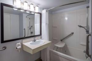 a bathroom with a sink and a shower and a mirror at Travelodge Suites by Wyndham Saint John in Saint John