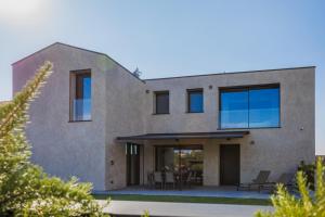 a modern house with glass doors and windows at Villa Greghe-Lusso con piscina in Lazise