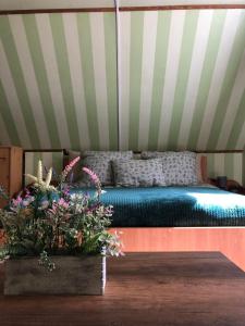 um quarto com uma cama numa tenda com flores em Váradi Vendégház em Doboz