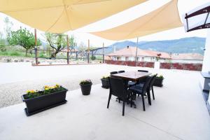 a table and chairs under an umbrella on a patio at Pina's house in Pianillo