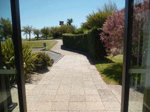 a walkway leading to a garden with bushes and trees at ibis Saintes in Saintes