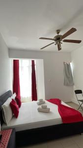 a bedroom with a large bed with a ceiling fan at Maison Residencial casa de ferias in Pedra Badejo