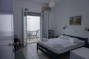 um quarto com uma cama e vista para uma varanda em Soula Rooms Tinos em Tinos Town