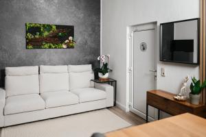 a living room with a white couch and a tv at Waldstübchen Quedlinburg in Quedlinburg