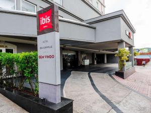 a building with a bus sign in front of it at ibis Joinville in Joinville
