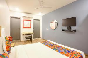 a bedroom with a bed and a tv on the wall at FabHotel Vivek in Muthiganj