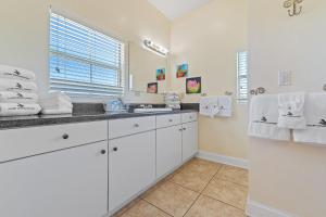 a white bathroom with a sink and a mirror at Bella Villa Guest Suite in Perdido Key +41 photos