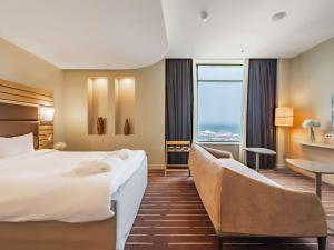 een hotelkamer met een groot bed en een bureau bij Mercure Sochi Centre Hotel in Sotsji
