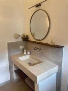 a bathroom with a sink with a mirror on the wall at Vitabella Toscana in Seggiano