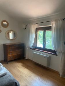 セッジャーノにあるVitabella Toscanaのベッドルーム1室(ドレッサー、カーテン付きの窓付)