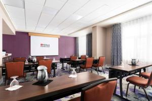 a conference room with tables and chairs and a projection screen at Hilton Garden Inn Calgary Airport in Calgary