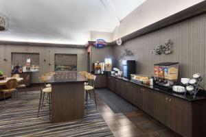 a restaurant with a bar with chairs and a counter at Baymont by Wyndham Copley Akron in Copley