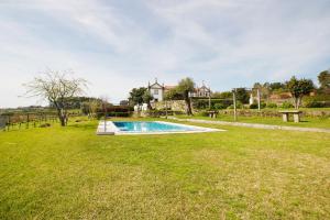 a swimming pool in the middle of a grass field at Casa do Solar in Proselo