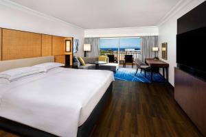 a hotel room with a bed and a living room at Hilton Guam Resort & Spa in Tumon