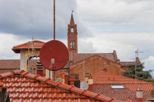 a church with a clock tower and red roofs at B&B Cristina e Stefano in Pisa