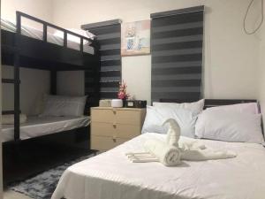um quarto com 2 beliches e um cisne na cama em 3-Bedroom bungalow in San Fernando Pampanga em San Fernando
