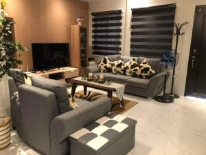 uma sala de estar com dois sofás e uma mesa em 3-Bedroom bungalow in San Fernando Pampanga em San Fernando