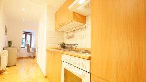 uma cozinha com armários de madeira e um forno de fogão branco em Peters Apartments - Zentrale Innenstadtlage em Fulda
