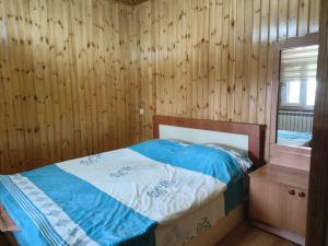 BasqalにあるBasqal Village Cottages & Restaurantの木製の壁のベッドルーム1室(ベッド1台付)