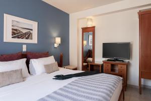 a hotel room with a bed and a television at Caldera Bay in Platanias