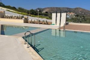 a swimming pool with blue water in a building at Seascape Kalyves in Kalyves