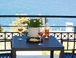 a blue table with two glasses of wine and a bottle at MY PHOS Boutique Apartments in Nikiana
