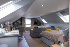 a attic bedroom with a bed and a couch at Ard Buidhe B&B in Daliburgh