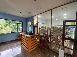 a bar in a store with a person sitting at a counter at Blue Sky Guest House And Restaurant in Nallathaniya
