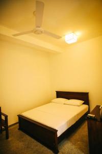 - une chambre avec un lit et un ventilateur de plafond dans l'établissement Laurel Residence, à Kandy