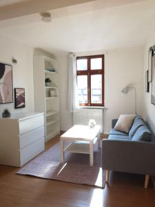 uma sala de estar com um sofá e uma mesa em Peters Apartments - Zentrale Innenstadtlage em Fulda