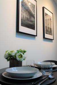 une table avec deux assiettes et un vase avec des fleurs dans l'établissement Kalamaja Loft Apartments, à Tallinn
