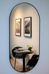 un miroir reflétant une table et des chaises dans la chambre dans l'établissement Kalamaja Loft Apartments, à Tallinn