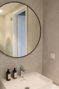 La salle de bains est pourvue d'un lavabo et d'un miroir. dans l'établissement Kalamaja Loft Apartments, à Tallinn