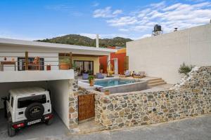 a house with a car parked in a garage at L'Maya Luxury Villa private pool, 2 Master BD, BBQ in Kalochorafitis