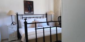 Schlafzimmer mit einem schwarzen Bett und weißen Kissen in der Unterkunft Apartman Victoria in Gradac