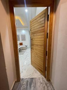 una gran puerta de madera en una habitación con pasillo en Havre de Douceur Maison Cosy Confort et Style en Dakhla