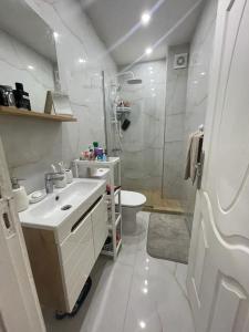 Baño blanco con lavabo y aseo en Havre de Douceur Maison Cosy Confort et Style en Dakhla