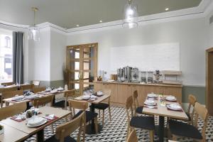 um restaurante com mesas e cadeiras e uma cozinha em Prince William Hotel em Londres