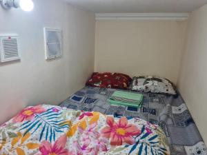 um pequeno quarto com uma cama com flores em Al karama spacious hostel no Dubai