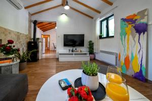 a living room with a table and a tv at Villa Silentio Luxury with pool, jacuzzi & sauna in Podgora